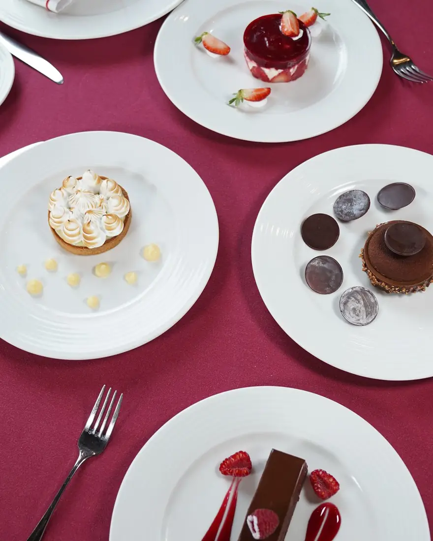Overhead of plated desserts on a magenta tablecloth