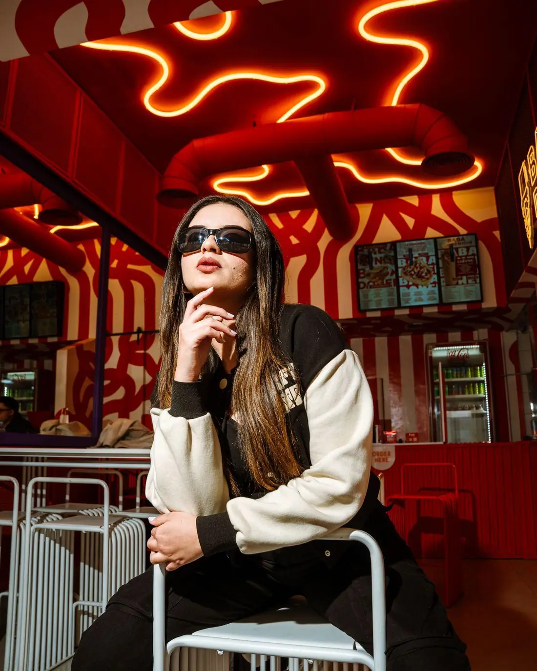 Model in sunglasses under the neon ceiling