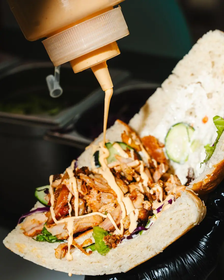 Sauce poured over a Baba Doner sandwich