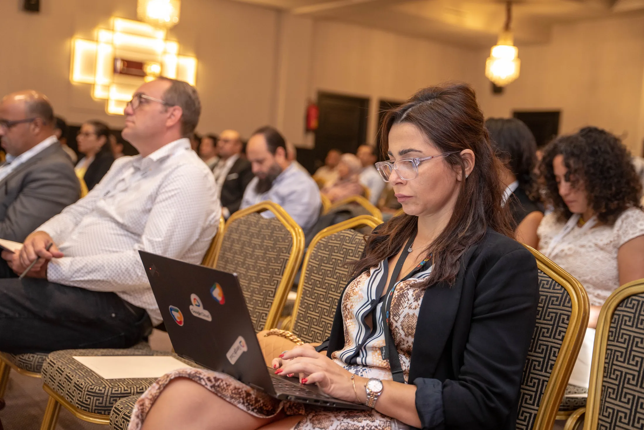 Guests taking notes on laptops during the talks